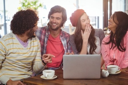 Laughing friends enjoying coffee with laptop in cafe-113562-edited
