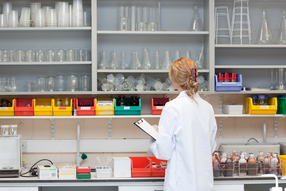 Serious female scientist writing on her clipboard in a laboratory.jpeg