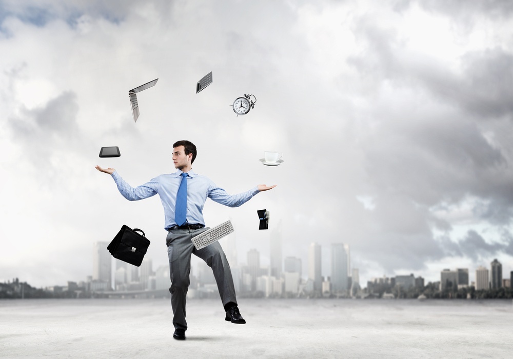 Young businessman juggling with business items against urban scene.jpeg